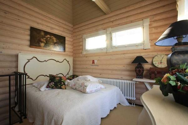 The design of the bedroom in log homes is no different: light, calm tones and a few color accents