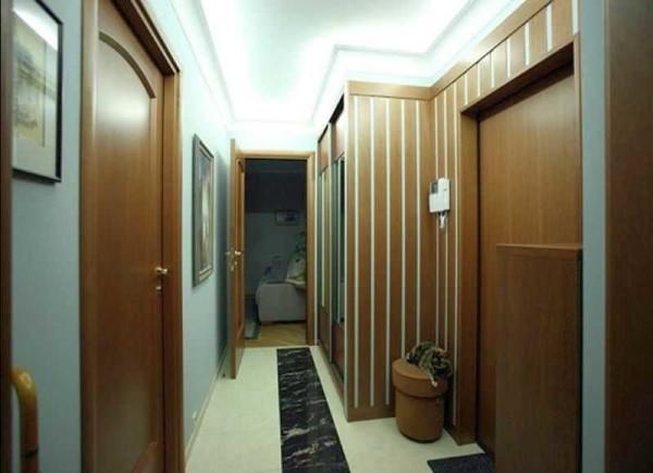 Dark furniture in the narrow hallway is compensated by bright lighting, but still the interior gives a gloomy impression