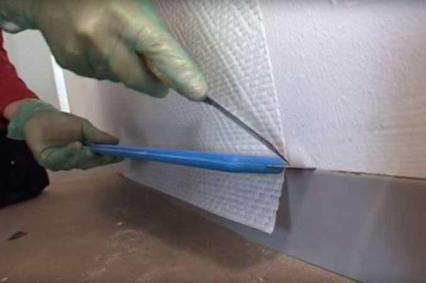 How to glue fiberglass wallpaper: trim off the excess