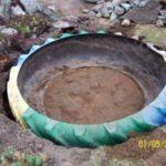 The cut tire is placed in the dug hole, pour some earth inside, leveling the bottom