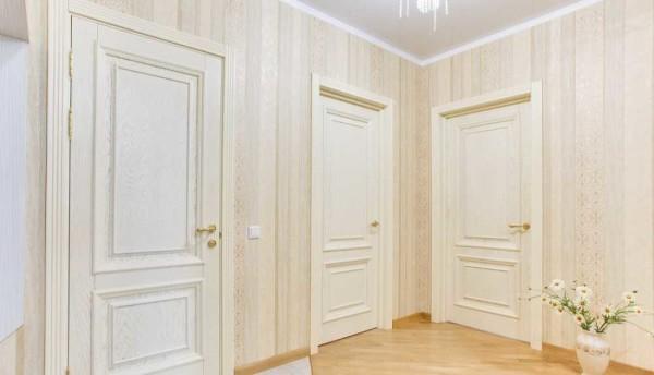 In the corridor with light-colored doors wallpaper looks more organically light-colored wallpaper