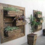 A panel of boards and crates with flowers is stylish