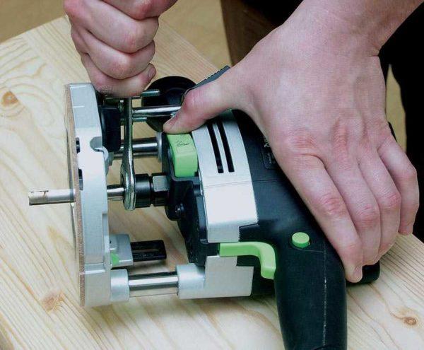 Working with a hand-held router on wood and other materials starts with setting the router bit